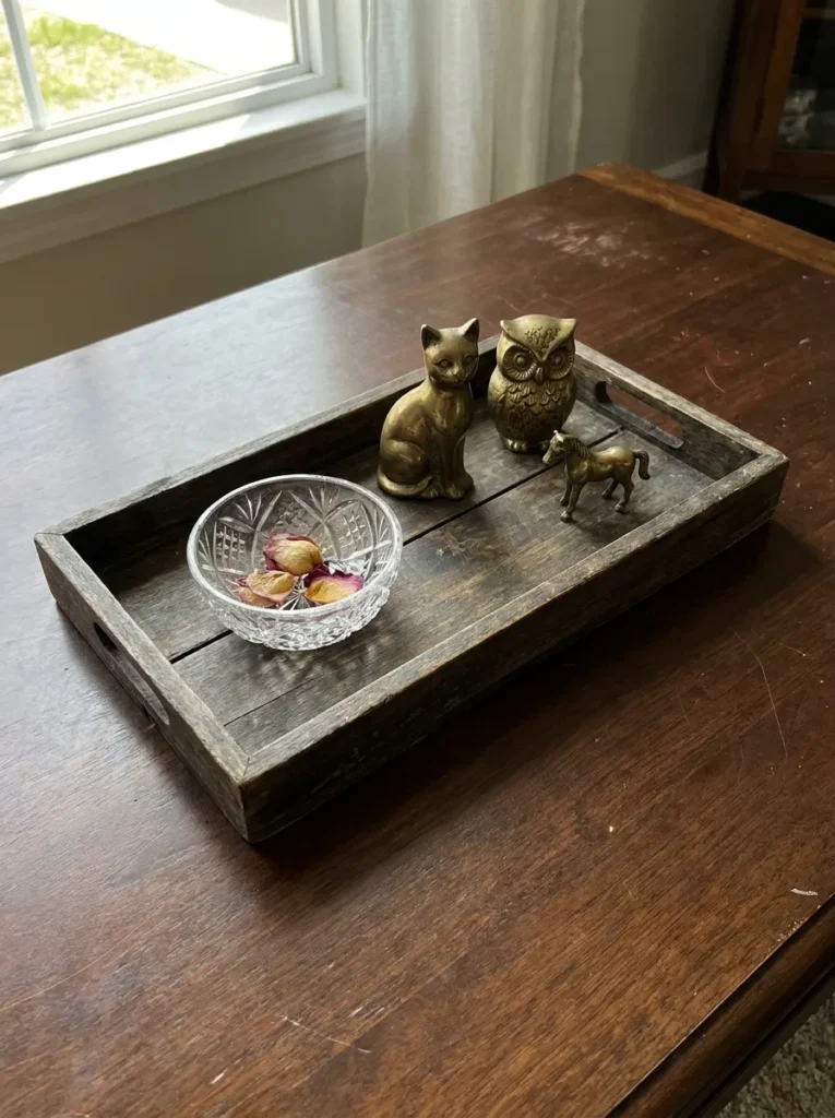 Vintage brass items grouped intentionally on a tray – curated vs cluttered styling