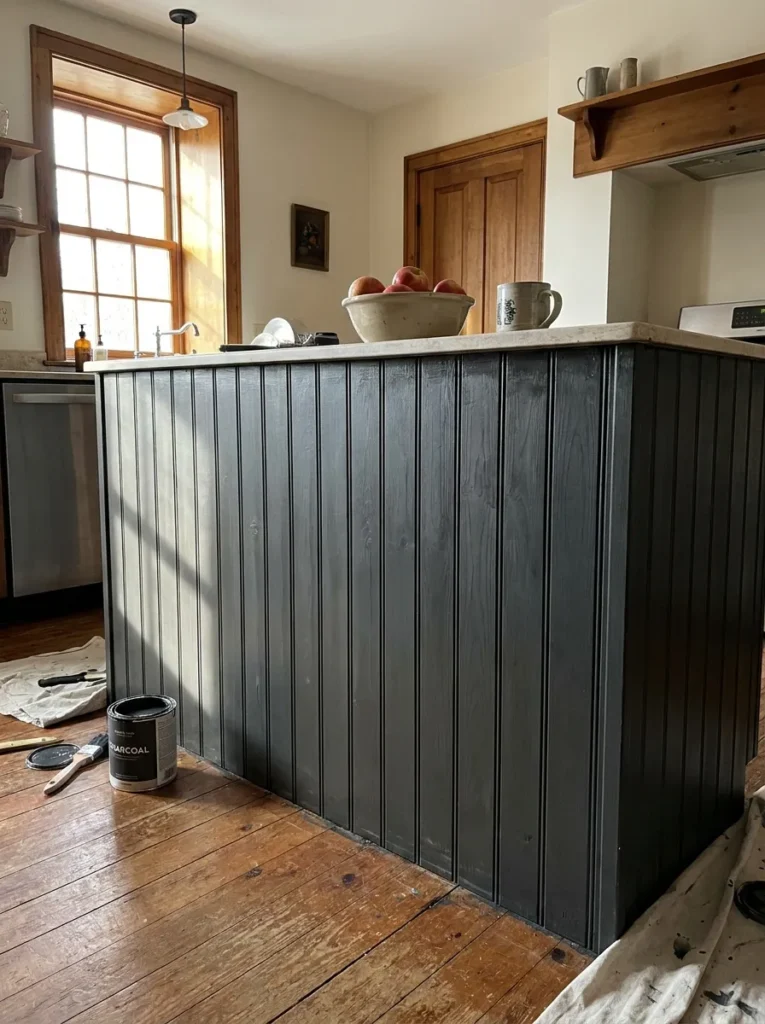 Kitchen island wrapped in beadboard paneling and painted charcoal gray