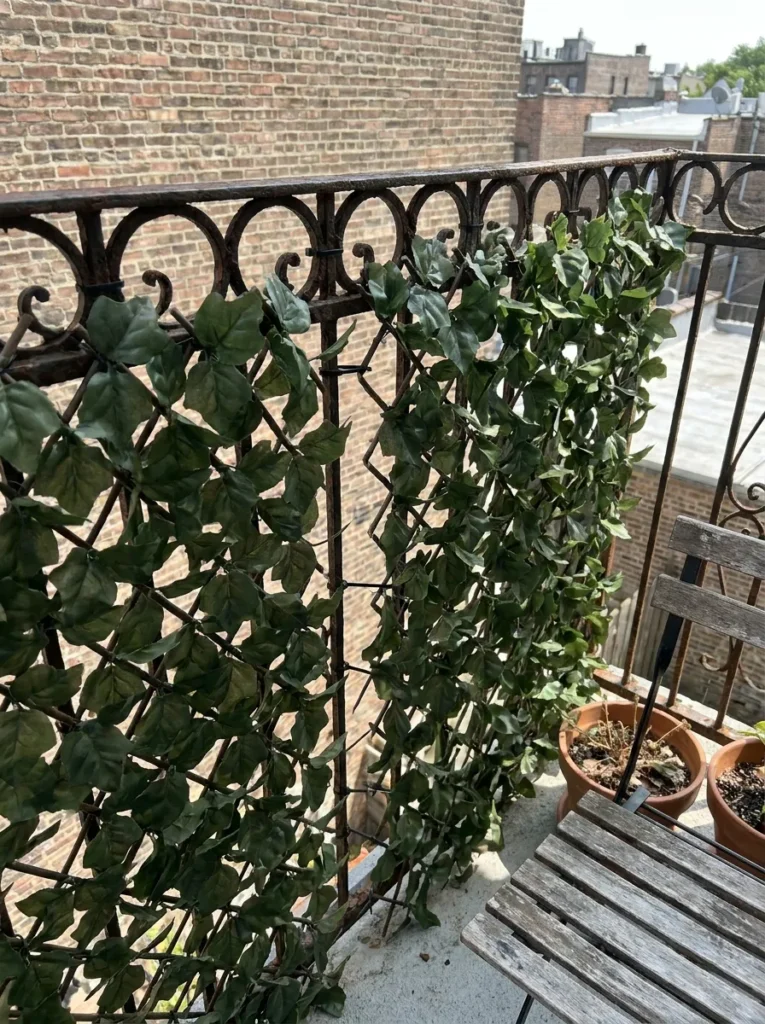 Faux ivy trellis zip-tied to balcony railing – budget privacy screen for renters