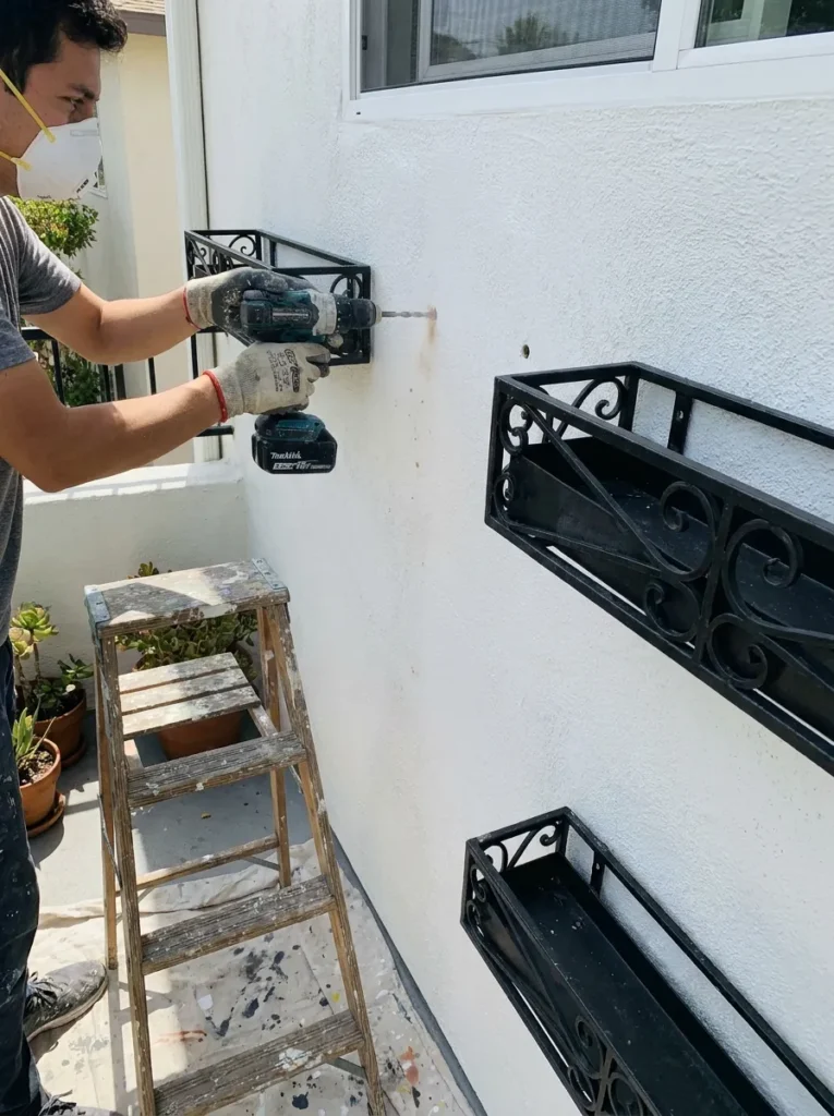 Freshly painted white balcony walls with mounted planters – permanent condo balcony upgrades