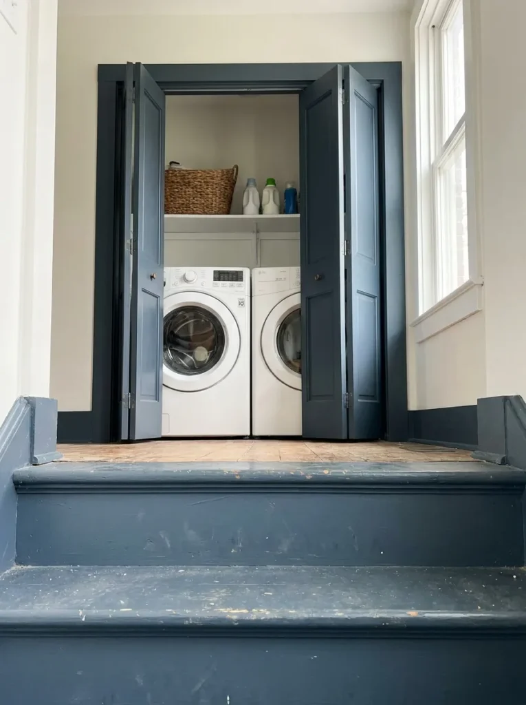 Slate blue painted trim and doors framing a small laundry closet