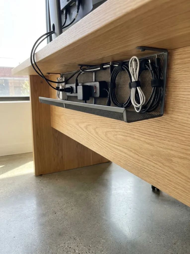 Under-desk cable management tray hiding computer cords