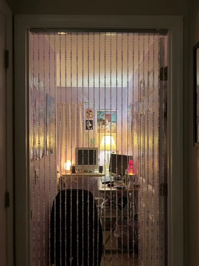 Iridescent purple acrylic beaded curtain hanging in a closet doorway frame