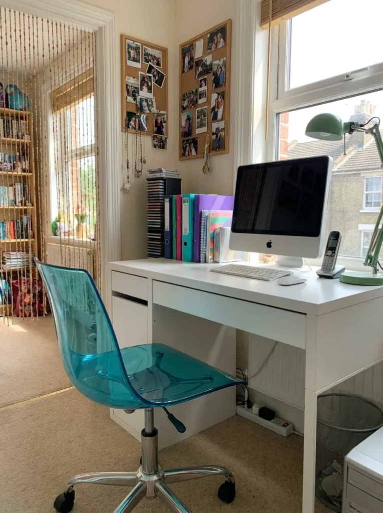 Transparent aqua blue polycarbonate shell desk chair placed at a white table