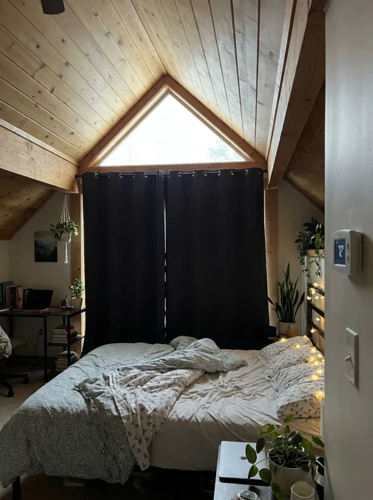 Thick thermal blackout curtains covering an attic bedroom window