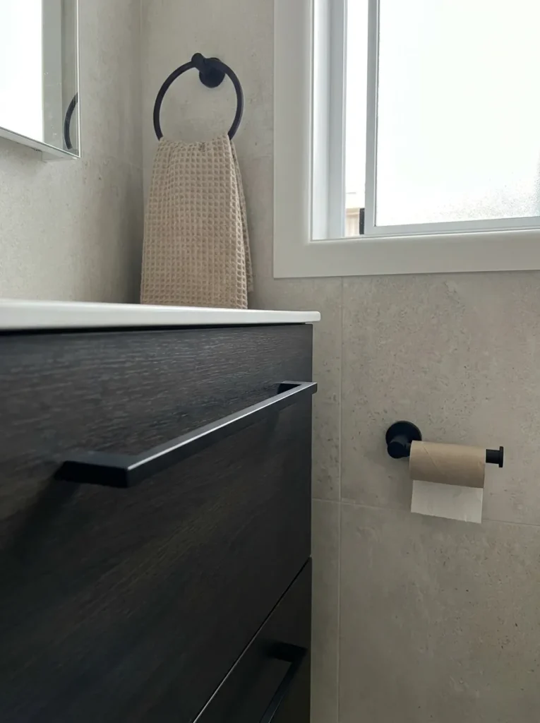 Cohesive matte black hardware tying a small bathroom design together