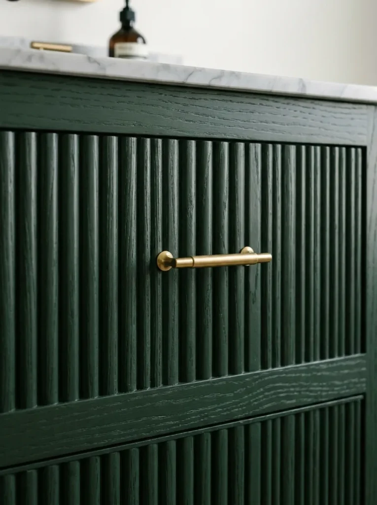 Close up of reeded vertical wood ridge patterns on a forest green vanity cabinet